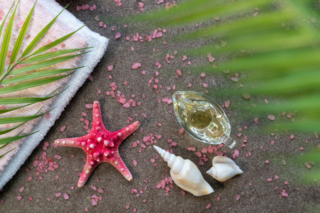 Starfish, seashells, terry towel and candle on the sand. Spa and wellness conceptの写真素材