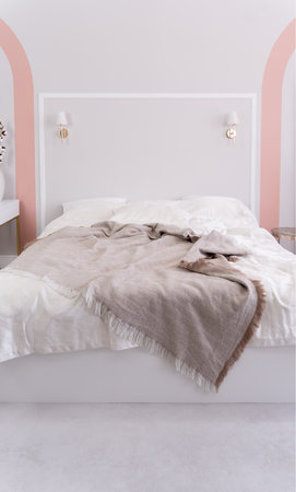 Minimalist bedroom with unique wavy wall design, illuminated by natural light. Sleeping conceptの写真素材