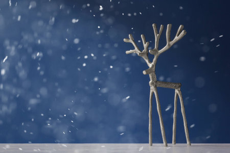 Souvenir silver deer on a blue background in snowの写真素材