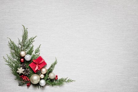 Green branches and Christmas balls. Christmas decor on a light background. New Years gift in a small...