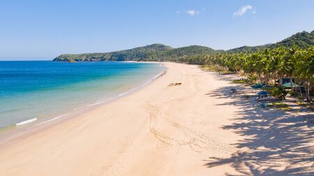 Wide tropical beach with white sand and small islands, top view. Nacpan Beach El Nido, Palawan....