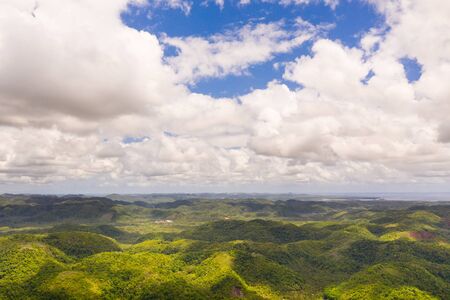 Hills with rainforest, aerial view. Tropical landscape with the jungle. Tropical climate, nature of the Philippines. Hilly terrain and sky with big clouds.の写真素材