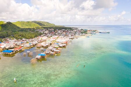 Sea port in the city of Dapa, Philippines. Fishing village and ships, view from above. Seascape in...