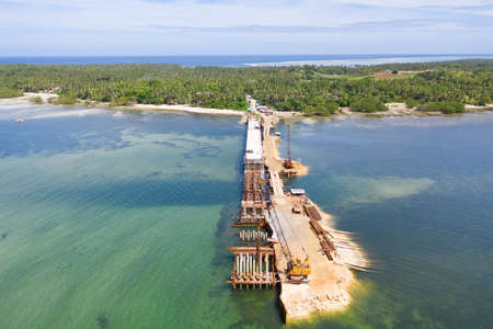 Construction of a bridge across the bay. Construction equipment on the bridge, top view. New bridge...