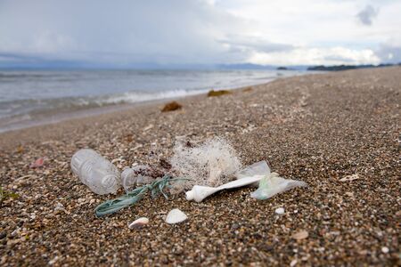 Beach pollution. Plastic bottles and other trash on sea beach. Ocean pollution. Plastic trash on the seashore.の写真素材