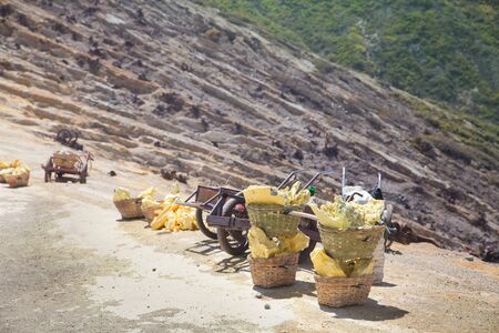 BASKET OF SULFUR ON KAWAH IJEN VOLCANO. Heavy basket laden by pieces of natural sulfur to carry by...