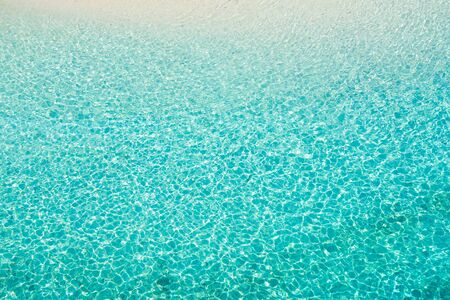 Sea surface in a turquoise lagoon, top view. The texture of sea water. Transparent turquoise sea...
