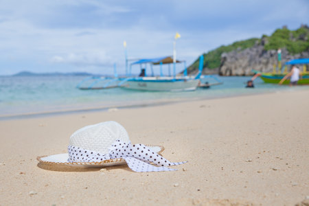 Hat on a white sandy beach. White sand. Sea traveling. Concept summer beach holiday.の写真素材