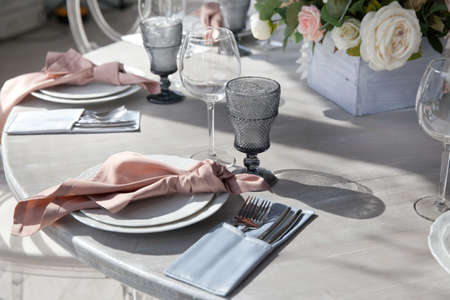 Romantic atmosphere in the cafe. Reserved table in the restaurant. Flowers and cutlery on the table.