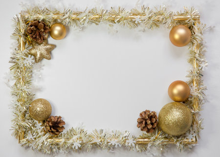 Photo frame, golden decorations on white background. Christmas, winter, new year concept. Flat lay, top view, copy space. Golden Christmas border of baubles.の写真素材