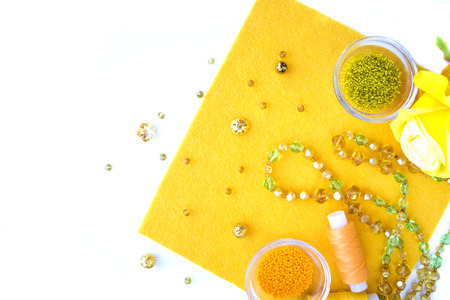 A set of materials for needlework in yellow color on a white background. 