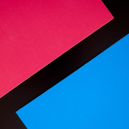 Dark flat lay background with color paper sheets. Black, blue and pink.の写真素材