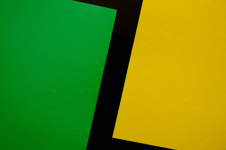 Dark flat lay background with color paper sheets. Black, green and yellow.の写真素材
