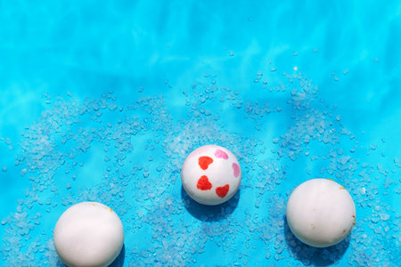 bombs and bath salt on blue background with water reflexes, shower cosmetics concept, top view, copy spaceの写真素材