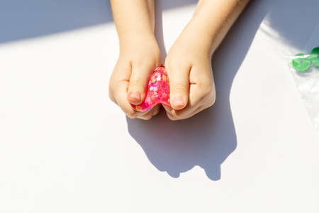 baby hands holding slime on white background close upの写真素材