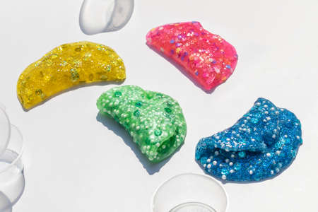 pink, yellow, blue and green slimes on white background, shiny texture with decorations