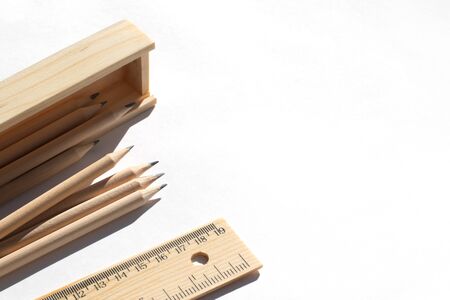 Pencil case and pencils are lying on the table in bright daylight. Natural unpainted wood. Eco-friendly materialsの写真素材