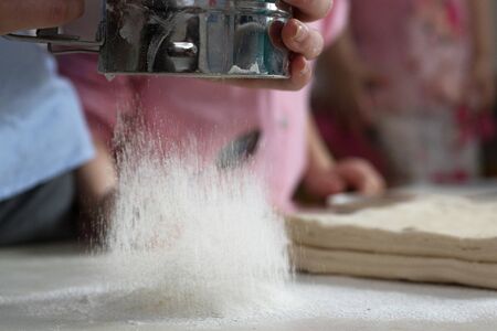Children mold cheesecakes from dough. Kitchen table in flour. Warm relationships children.