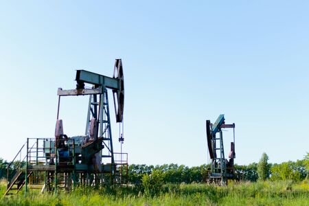 Oil pump or pump installation in a flowering field. Problems of environmental production.の写真素材