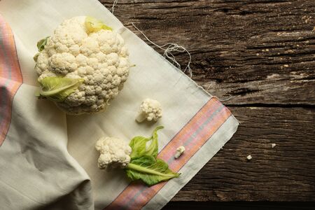 Cooking Cauliflower. Top view, wooden table, a whole head of cauliflower. Healthy eating conceptの写真素材