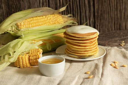American pancake with cornmeal cream on a rustic wooden background. Minimal style in natural colors....