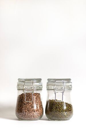 Mash and red lentils are tightly closed in a glass bowl. Legumes are stored in banks. Food stocks for future use. Safe and environmentally friendly food storage. Vegetable protein. Minimalism in the design of space.の写真素材