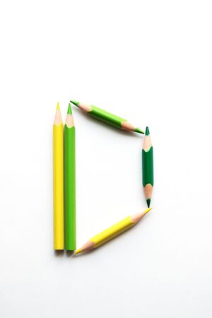 Letter D composed of colored pencils on white paperの写真素材