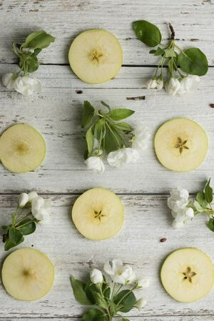 Apple tree flowers pattern and apple slices on white woodenの写真素材