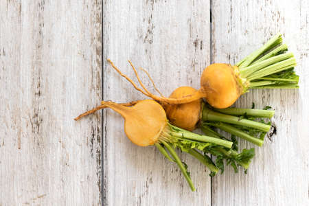 Slice of yellow turnip with leaves on a white wooden background. Useful vitamins from root vegetables all year roundの写真素材