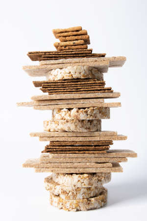 The crispbreads are stacked. Healthy crispy bread on a white background. Vegetarian and diet food. Close-up photo.の写真素材
