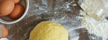 Kneading the Dough. On the table are flour, napkin, eggs and shells