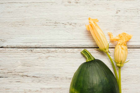 Fresh zucchini with flowers on white wooden backgroundの写真素材
