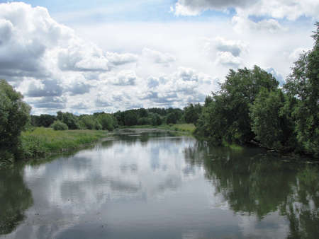 clouds are reflected in river waterの写真素材