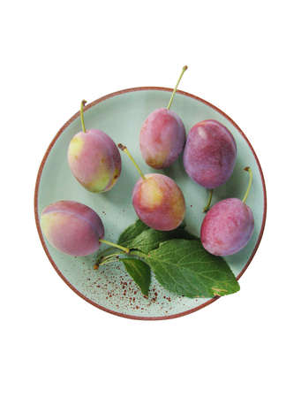 Plums on a plate isolated on the white backgroundの写真素材