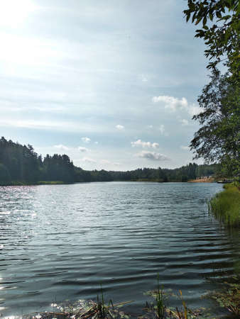 Lake and blue sky with clouds near the horizonの写真素材