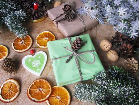 Merry Christmas and happy winter holiday. Christmas mood and gifts, dried sliced ââoranges, and nuts on table backgroundの写真素材