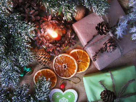 Merry Christmas and happy winter holiday. Christmas mood and gifts, dried sliced ââoranges, burning candle on table backgroundの写真素材