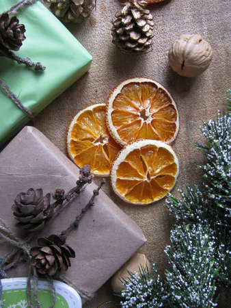 Merry Christmas and happy winter holiday. Christmas mood and gifts, dried sliced ââoranges, and nuts on table backgroundの写真素材
