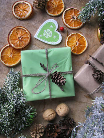 Merry Christmas and happy winter holiday. Christmas mood and gifts, dried sliced ââoranges, and nuts on table backgroundの写真素材