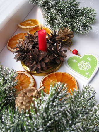 Merry Christmas and happy winter holiday. Christmas mood and decoration, dried sliced ââoranges, burning candle on a light backgroundの写真素材