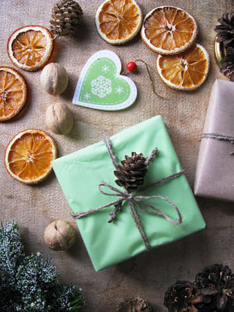 Merry Christmas and happy winter holiday. Christmas mood and gifts, dried sliced ââoranges, and nuts on table backgroundの写真素材