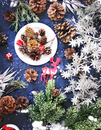 Winter holidays. Holiday decorations, pine cones, and garlands on a blue knitted backgroundの写真素材