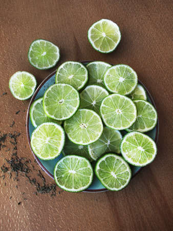 Sliced limes in circles, and thyme on a dark wooden backgroundの写真素材