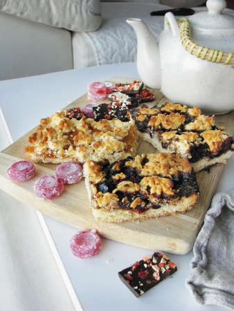 Pieces of pie with jam, and teapot on a tableの写真素材