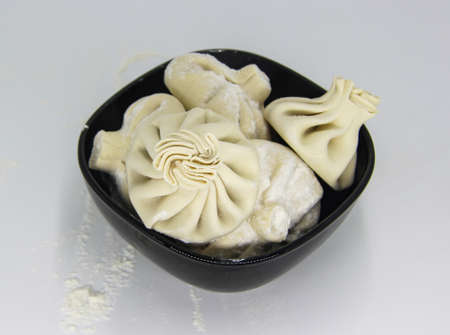 delicious Khinkali with cilantro on plate on black wooden tableの写真素材