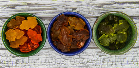 Multi-colored delicious fruit gummy candies in three platesの写真素材