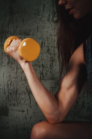 yellow dumbbells in a female handの写真素材