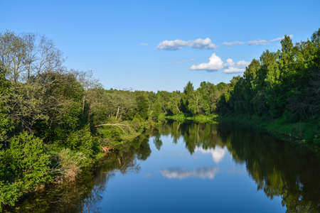 view of the river in the sunlight and the reflection of the cloud above the riverの写真素材