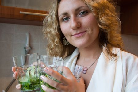 Woman pn the kitchen holds coctailsの写真素材