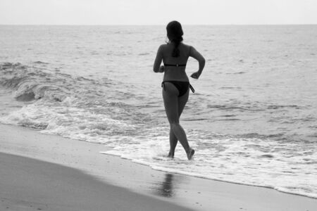 Woman jogging at the beach, black and whiteの写真素材